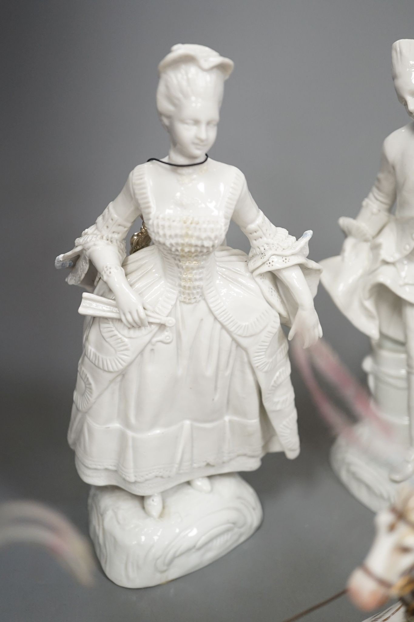 A large Italian porcelain carriage group and a pair of Italian white porcelain figure of a lady and a man 54cm